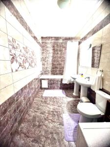 een badkamer met een wastafel en een toilet bij 215 Рядом с Байтереком для 1-5 чел с 2 большими кроватями и диваном in Astana