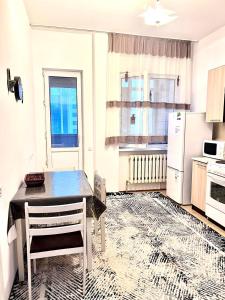 a kitchen with a dining table and a refrigerator at 215 Рядом с Байтереком для 1-5 чел с 2 большими кроватями и диваном in Astana