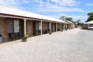 a row of buildings with potted plants on the sidewalk at Lake Albert Motel in Meningie