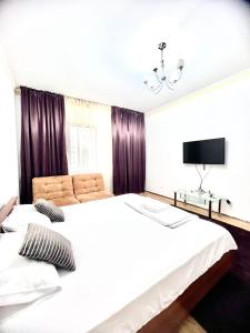 a bedroom with two beds and a tv on the wall at 215 Рядом с Байтереком для 1-5 чел с 2 большими кроватями и диваном in Astana