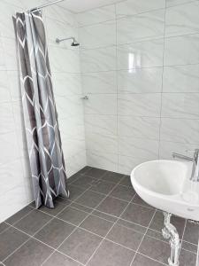 a white bathroom with a shower and a sink at Twin City Motor Inn in Wodonga