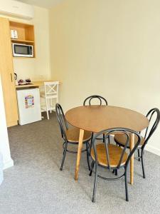 a table and chairs in a room with a kitchen at Twin City Motor Inn in Wodonga