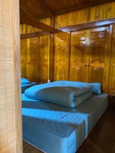Duas camas num quarto com paredes de madeira em Hillside homestay em Ha Giang