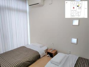 um quarto com 2 camas e uma mesa de cabeceira com uma cama quadrada em Kumamoto - House - Vacation STAY 83489 em Kumamoto