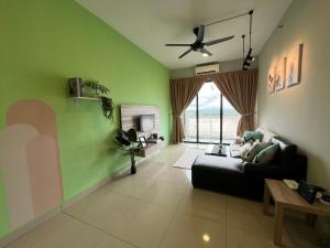 sala de estar con sofá negro y paredes verdes en RiverView 8PAX 3BR in KBtown PS4, Netflix A-1-2, en Kota Bharu