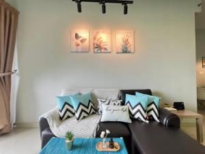 a living room with a black couch with pillows at RiverView 8PAX 3BR in KBtown PS4, Netflix A-1-2 in Kota Bharu