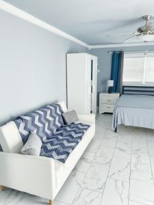 a white bedroom with a bed and a white couch at Casa Agora in St Petersburg