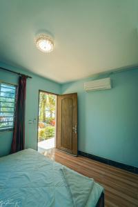 1 dormitorio con 1 cama y puerta con ventana en Koh Rong 71 Guesthouse, en Koh Rong
