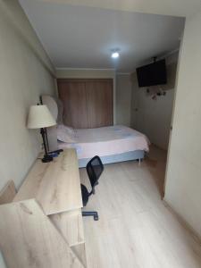 1 dormitorio con cama, escritorio y silla en Hermoso condominio estilo Urban, en Lima