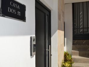 une porte noire avec un panneau sur le côté du bâtiment dans l'établissement Departamentos DOS21, à Mazatlán