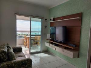 Il comprend un salon doté d'une télévision à écran plat et d'un canapé. dans l'établissement Apartamento em frente a praia, à Praia Grande