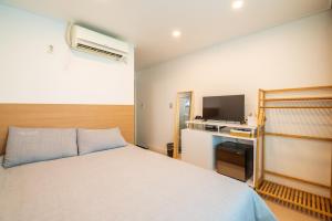 a bedroom with a bed and a television at Parkavenue Guesthouse in Seoul