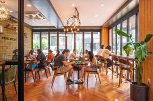 a group of people sitting at tables in a restaurant at Parkavenue Guesthouse in Seoul