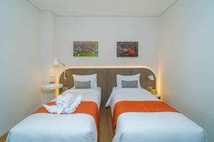 um quarto com duas camas com toalhas em Se.nandung Living and Space em Malang