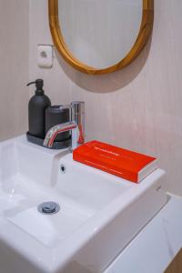 ein rotes Buch auf einem Waschbecken im Bad in der Unterkunft Se.nandung Living and Space in Malang