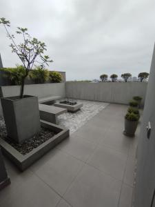 a courtyard with two benches and a potted tree at Hermoso condominio estilo Urban in Lima