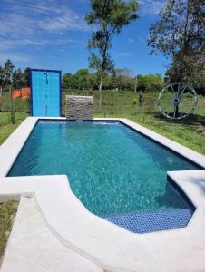 a swimming pool with blue water in a yard at Pelado Róga in Villa Florida