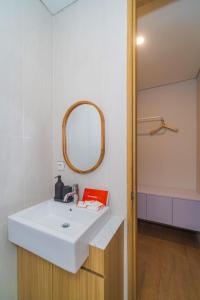 a bathroom with a white sink and a mirror at Se.nandung Living and Space in Malang