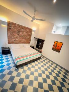 a bedroom with a bed and a brick wall at The Orange House Santa Marta in Santa Marta