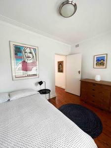 1 dormitorio con 1 cama y vestidor con una foto en la pared en Stylish & Sunlit Bellevue Hill, en Sídney
