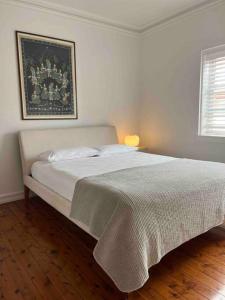 1 dormitorio con 1 cama con una foto en la pared en Stylish & Sunlit Bellevue Hill, en Sídney