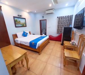 a bedroom with a bed and a table and chairs at COZY Hotel HCM in Ho Chi Minh City
