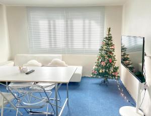 a living room with a christmas tree and a white table at Stay Yeoun Cheongwol 강남대치동 한티역 삼성역 대치역 강남세브란스병원 코엑스근처 in Seoul