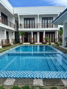 a swimming pool in front of a house at Haven Suites Siargao in General Luna