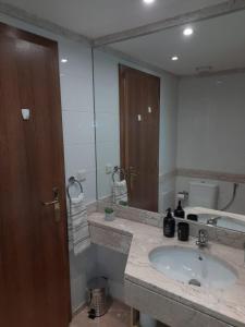 La salle de bains est pourvue d'un lavabo et d'un grand miroir. dans l'établissement Duplex da Fontinha, à Santa Cruz