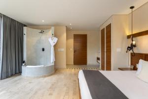 una habitación de hotel con una cama y una bañera en Collection O Faisano Boutique Luxury Hotel, Tulum Beach, en Tulum 68 fotos más