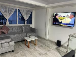 Il comprend un salon doté d'un canapé et d'une télévision à écran plat. dans l'établissement The Dreams Alojamineto, à Armenia