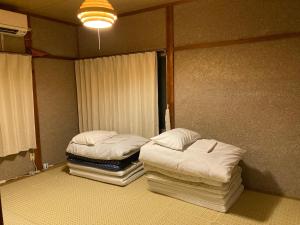 2 camas individuales en una habitación con ventana en おばあちゃんち, 