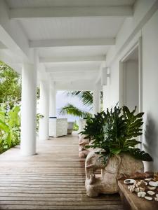a porch with white columns and plants on it at Tamarind Beach Estate in Port Vila