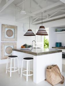 a kitchen with a white island with stools at Tamarind Beach Estate in Port Vila