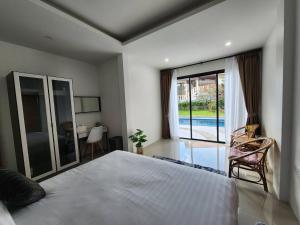 a bedroom with a bed and a view of a pool at PoolVilla 234 Patong in Patong Beach