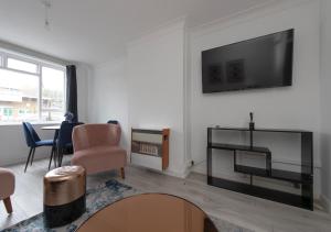 a living room with a flat screen tv on a wall at Prime London Location 3-Bed Flat in London
