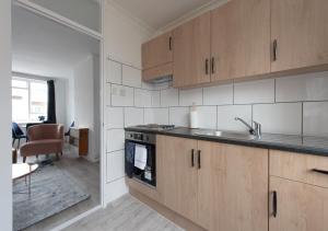 a kitchen with a sink and a stove top oven at Prime London Location 3-Bed Flat in London