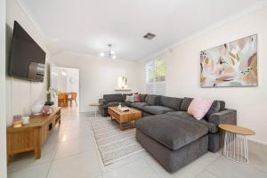 sala de estar con sofá y mesa en Petal and Bloom - 3BR Family CBD en Bowden