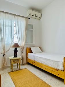 1 dormitorio con 1 cama y 1 lámpara en una mesa en Dar almasyaf, maison bord de mer, en Gabès