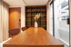 a wooden table with a vase of flowers on it at Nowness in Mexico City