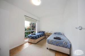 斯蒂基斯霍爾米的住宿－Bluefin On Theresa，一间卧室设有两张床和窗户。