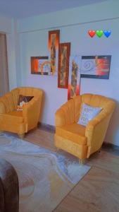two orange couches in a living room with at GP homes in Nyeri