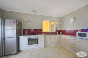 a kitchen with white appliances and red tiles at Bluefin On Theresa in Portland