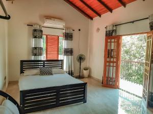 1 dormitorio con 1 cama en una habitación con ventanas en New White House Ratnapura en Ratnapura