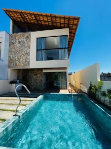una casa con piscina frente a una casa en Casa Flora Patacho en Pôrto de Pedras