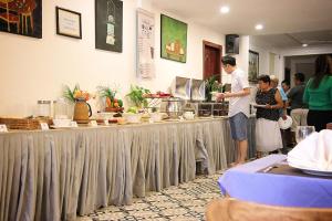 un hombre y una mujer parados en una cocina preparando comida en Grand Elevation Hotel, en Phnom Penh