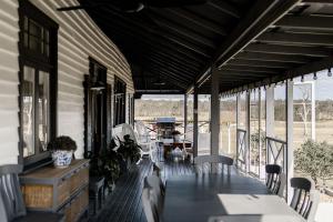 una veranda di una casa con tavolo e sedie di The Homestead at Corunna Station a Belford