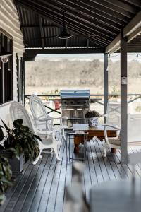 un portico con sedie bianche, un tavolo e una griglia di The Homestead at Corunna Station a Belford Altre 8 foto