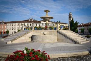 a fountain in front of a building with flowers at SIM residence in Maniago