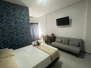 Habitación de hotel con cama y sofá en Hermoso Departamento en Condominio Céntrico Con piscina!, en Trinidad